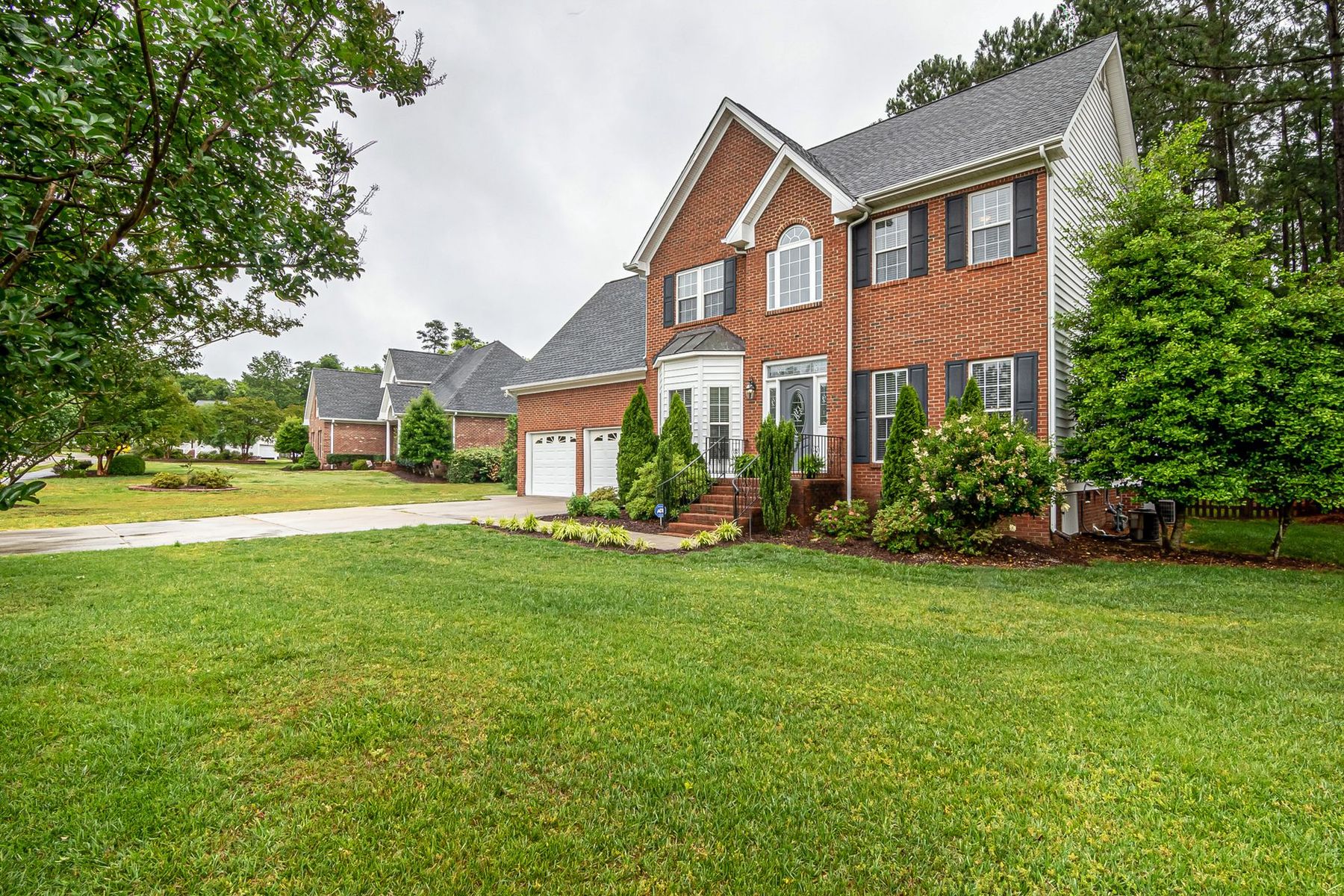 A brick family home in Pittsburgh with a cut, green front lawn