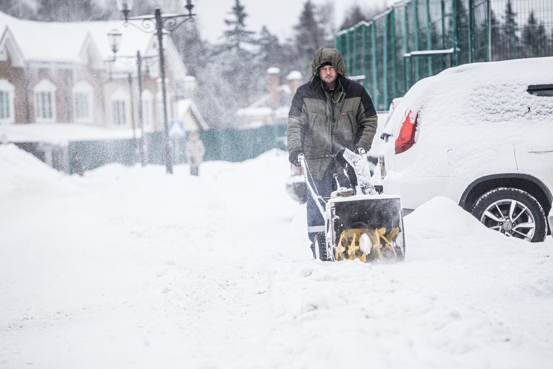 Clearing a snowy driveway with a snow blower